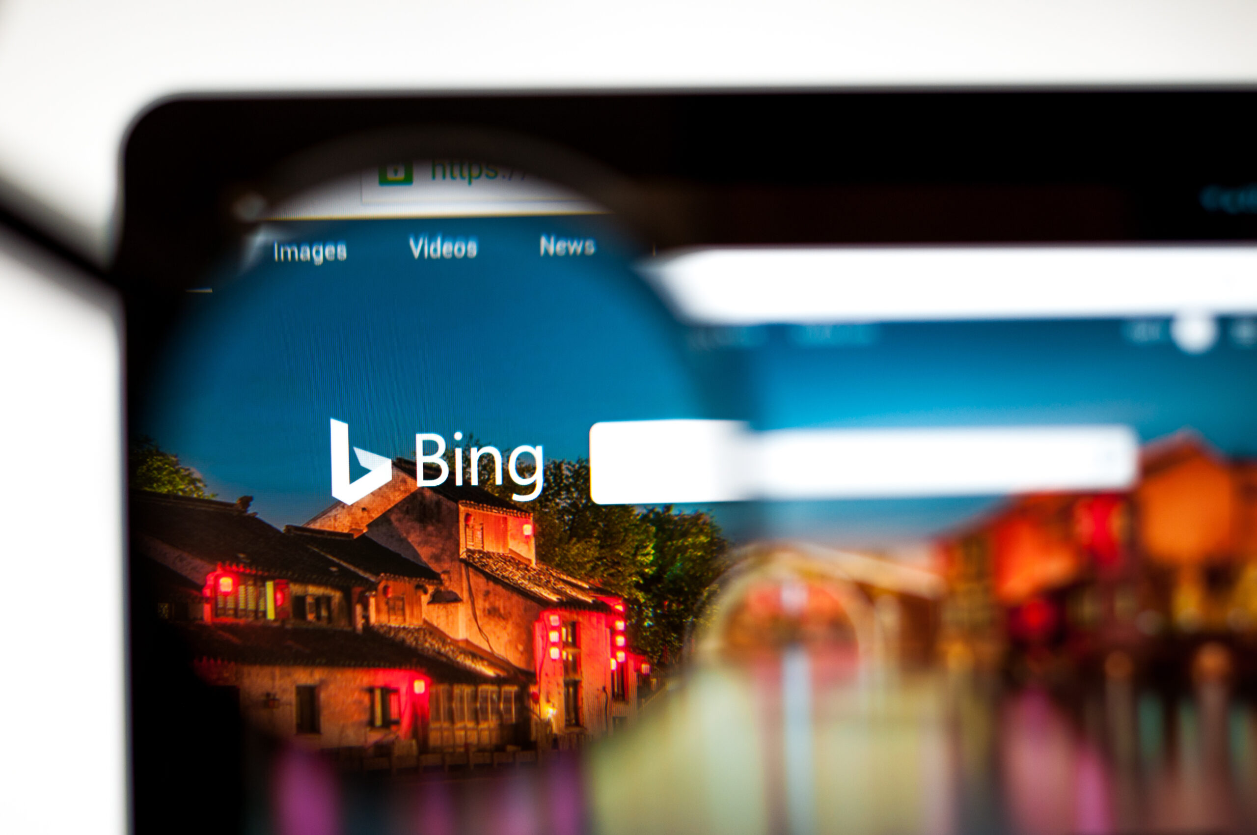 Magnifying glass over the Microsoft Bing logo on a laptop